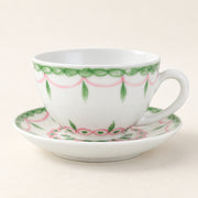 AI-assisted concept image of a white cup and saucer with pink swags and green leaf details.