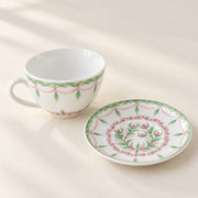 AI-assisted concept image showing the botanical cup beside its matching floral saucer.