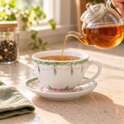 AI-assisted concept image of tea being poured into the botanical cup on its matching saucer.