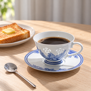 Fuyu Lotus Cup & Saucer — Cobalt Blue — styled use illustration; props and additional pieces excluded 9; AI-assisted image