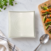 DXC Crystal White Square Plate — styled use illustration; props and additional pieces excluded 9; AI-assisted image