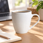 AI-assisted illustration of Pearl White Ribbed Breakfast Mug, desk pause setting; food and styling props are not included.