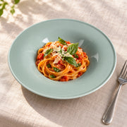AI-assisted illustration of Sage Wide-Rim Pasta Plate, tomato tagliatelle setting; food and styling props are not included.