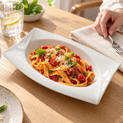AI-assisted illustration of Ivory Swept-Corner Serving Dish, pasta lunch setting; food and styling props are not included.