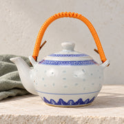 AI-assisted concept image of rice-grain teapot — orange handle: styled editorial view; food and props are not included.