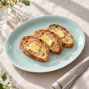 AI-assisted concept image of qingbai oval serving platter: styled setting view; food and props are not included.